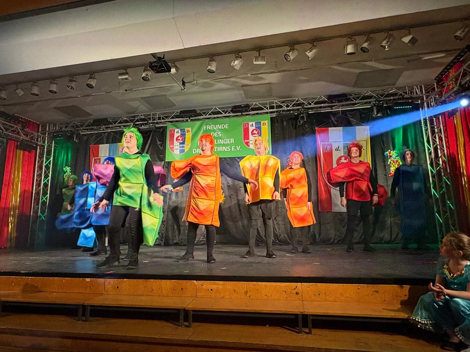 Die Gruppe tanzt in Tetris-Kostümen auf der Bühne.